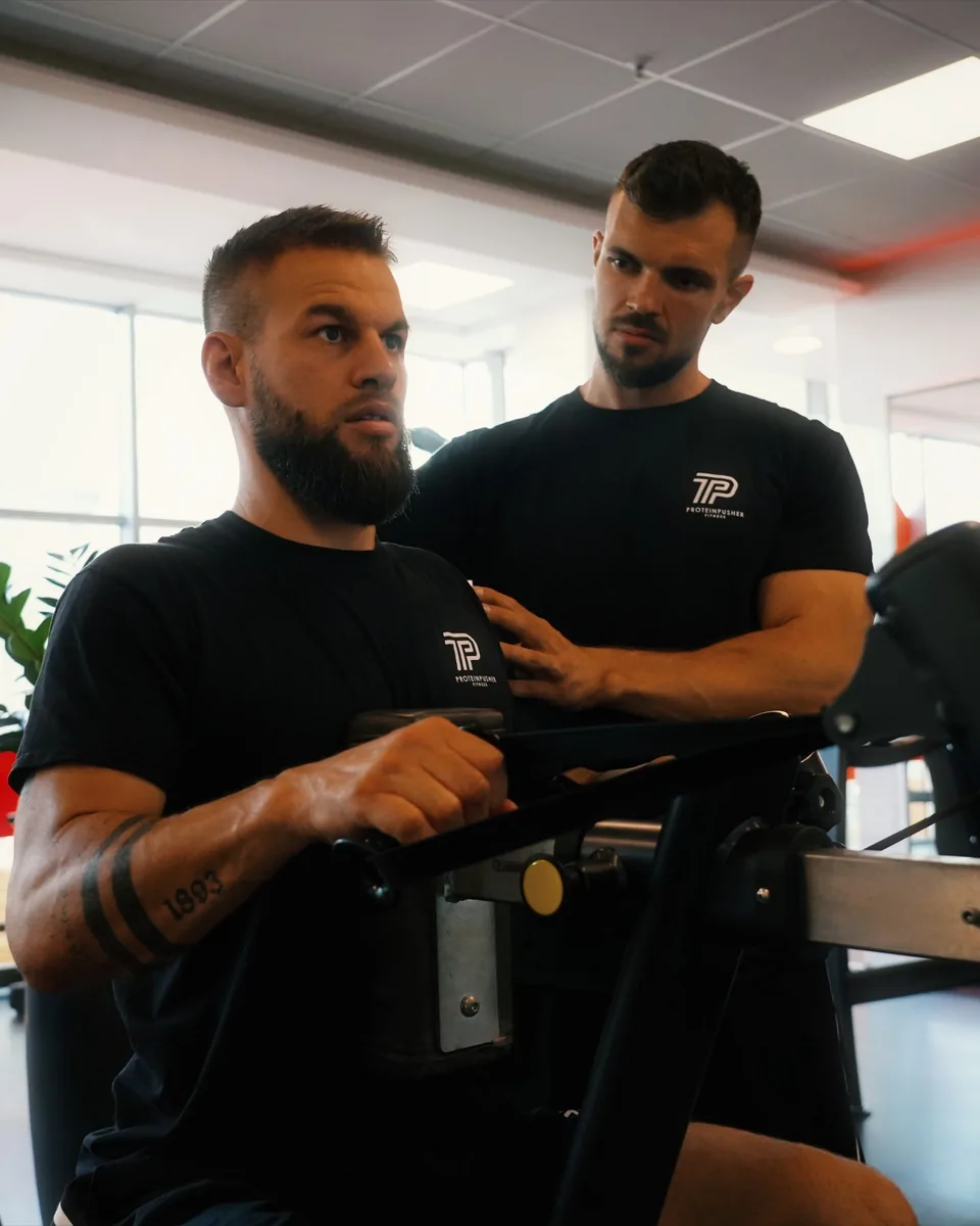 Personal Training in Linz: Adnan Lojic korrigiert einen Klienten an der Rudermaschine