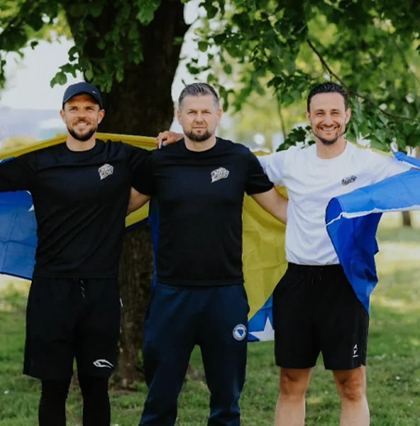 Adnan mit dem Team und der bosnischen Flagge